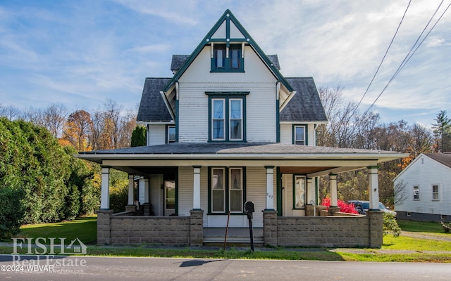 view of front facade with covered porch and a front yard