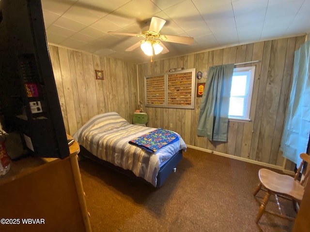 bedroom with wood walls, a ceiling fan, and baseboards