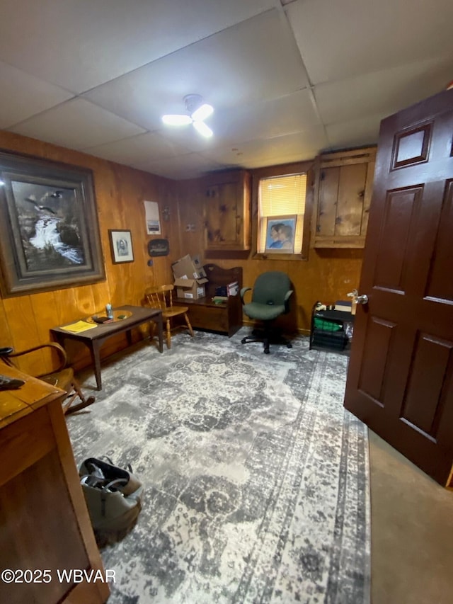 office area featuring a paneled ceiling and wood walls