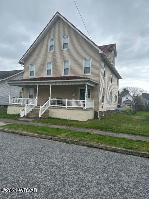 view of front facade featuring covered porch and a front lawn