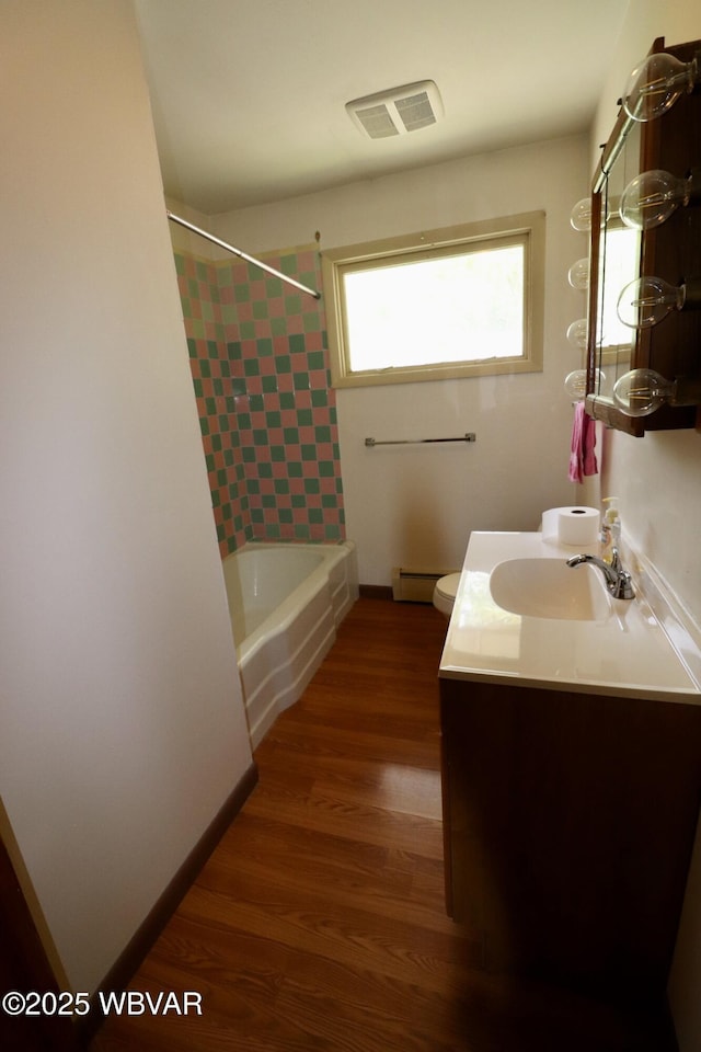 1964 Poco Farm Rd, Williamsport, PA 17701 - bathroom featuring a baseboard heating unit, vanity, shower / washtub combination, wood finished floors, and toilet