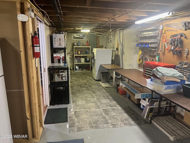 unfinished below grade area featuring a workshop area and washer / dryer