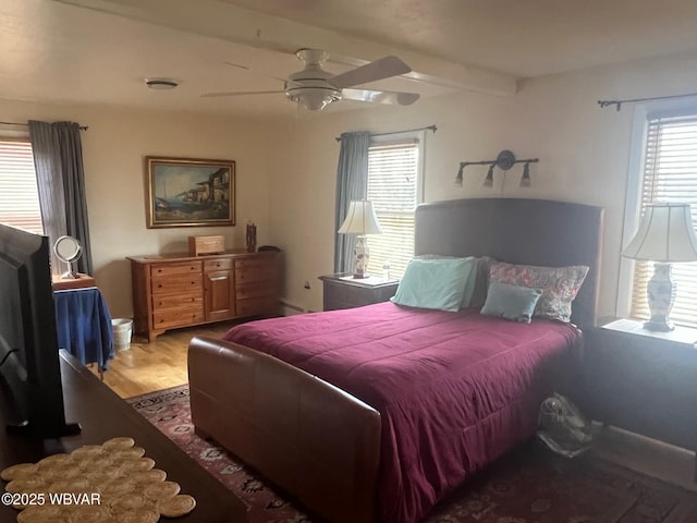 bedroom featuring light wood-style flooring, ceiling fan, and beam ceiling