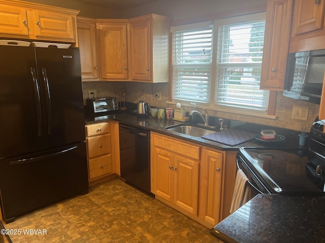 kitchen with black appliances, a sink, tasteful backsplash, and dark stone countertops