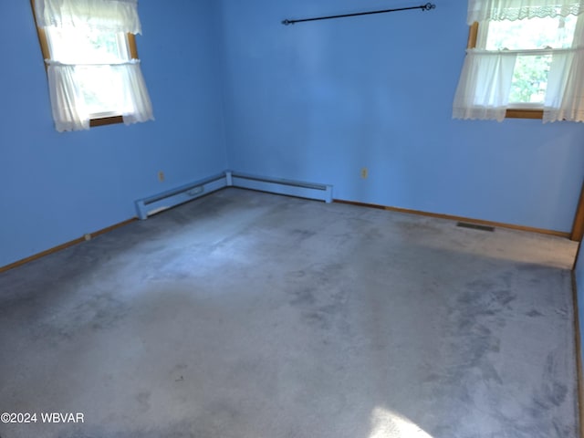 spare room featuring baseboard heating and carpet floors