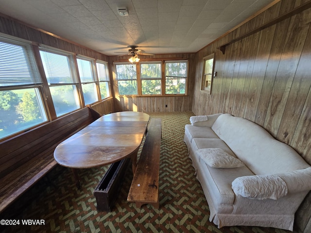 dining area with wood walls and ceiling fan