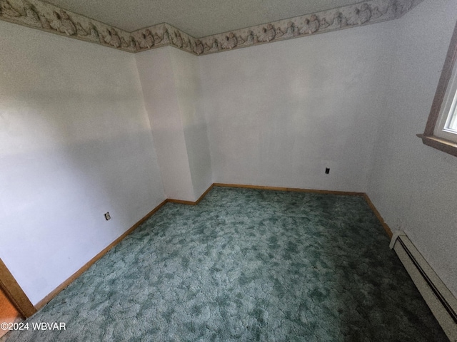 carpeted spare room with a textured ceiling and baseboard heating