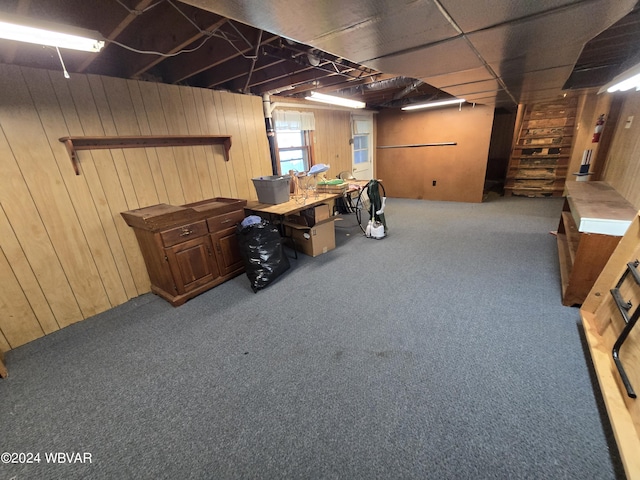 basement featuring carpet and wooden walls