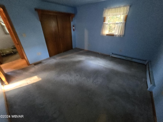 unfurnished bedroom featuring dark colored carpet and a closet