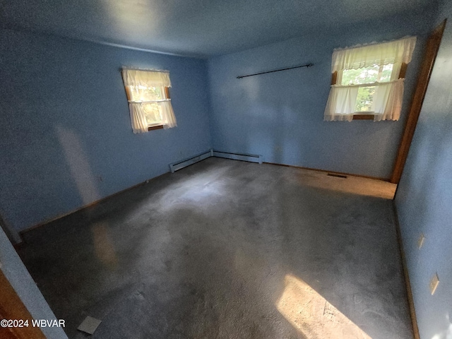 carpeted empty room with a wealth of natural light and a baseboard heating unit