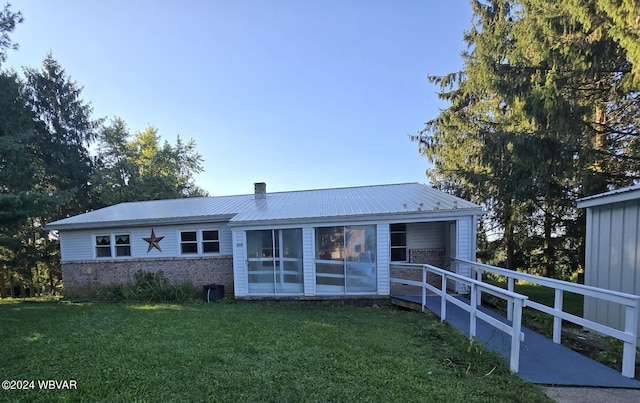 back of property featuring a lawn