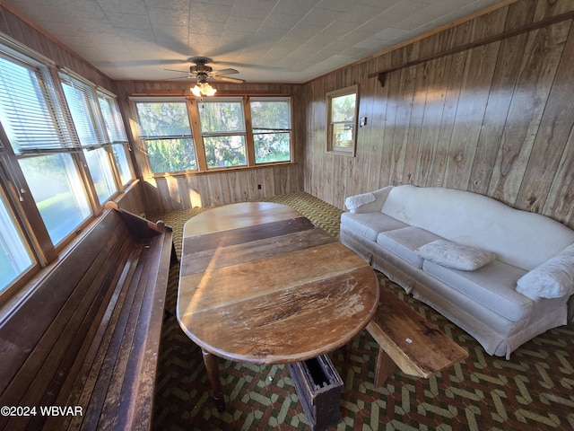 interior space with wooden walls and ceiling fan