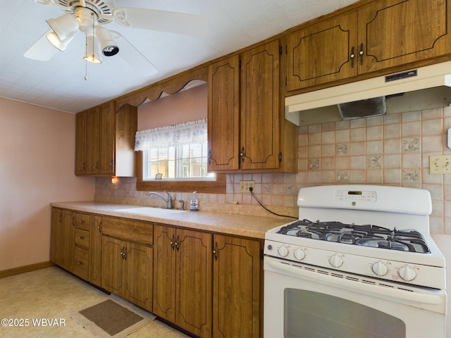 kitchen with ceiling fan, sink, white gas range, and tasteful backsplash