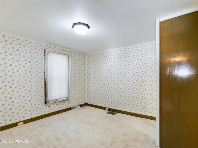 empty room featuring carpet and crown molding