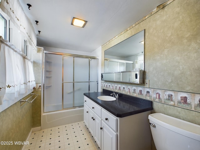 full bathroom featuring toilet, enclosed tub / shower combo, and vanity