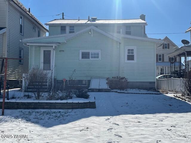 view of snow covered back of property