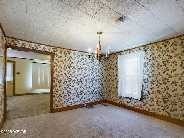 empty room with an inviting chandelier, crown molding, and carpet floors