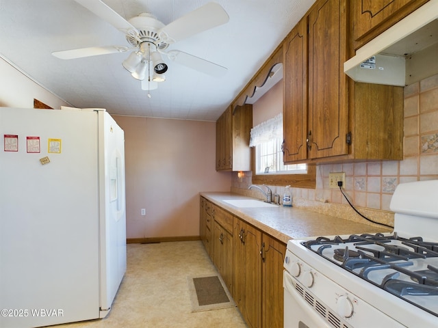 kitchen with sink, white appliances, tasteful backsplash, and ceiling fan