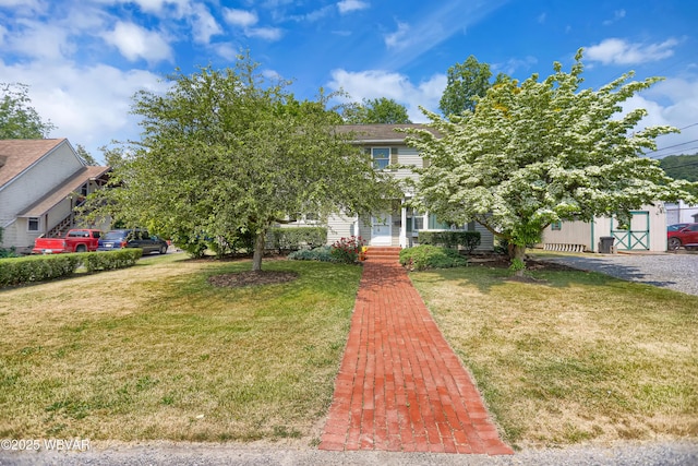 view of property hidden behind natural elements featuring a front yard