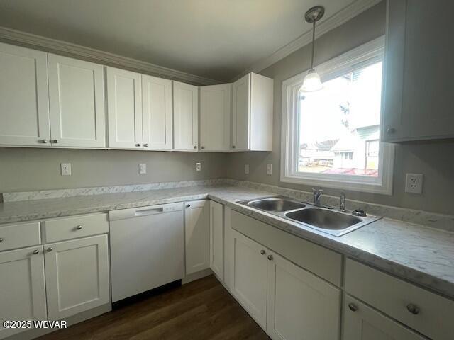 kitchen with white cabinetry, light countertops, white dishwasher, and a sink