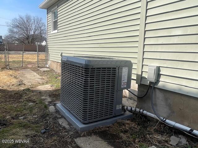 exterior details with a gate, cooling unit, and fence