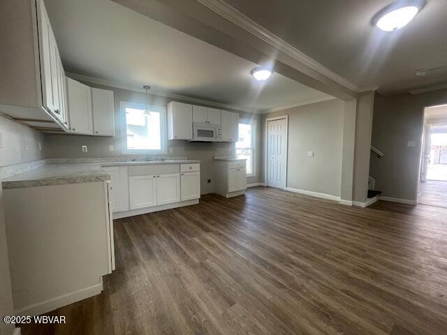 kitchen featuring crown molding, white microwave, and dark wood-style flooring