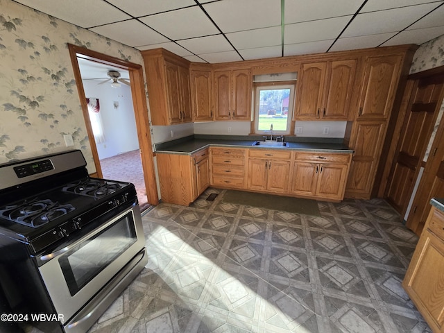 kitchen featuring gas range, a paneled ceiling, ceiling fan, and sink