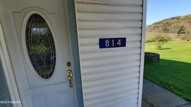 property entrance with a lawn