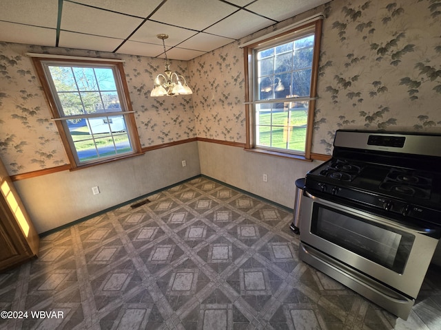 kitchen with gas stove, a paneled ceiling, dark parquet flooring, and a notable chandelier