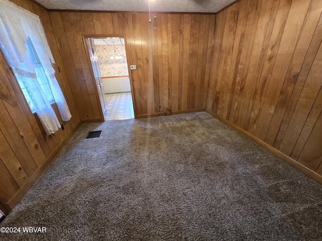 empty room with carpet flooring and wood walls