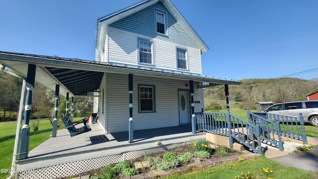 country-style home with covered porch and a front lawn