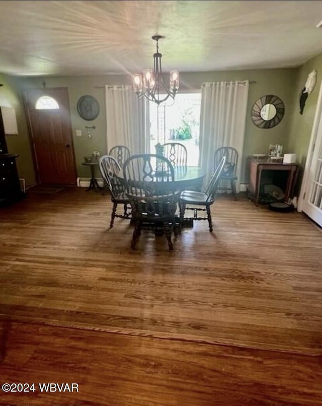 dining room with hardwood / wood-style flooring and an inviting chandelier