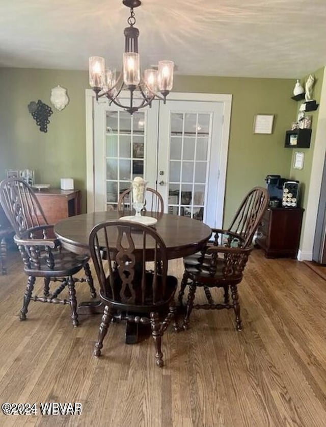 dining room with hardwood / wood-style floors, french doors, and a notable chandelier