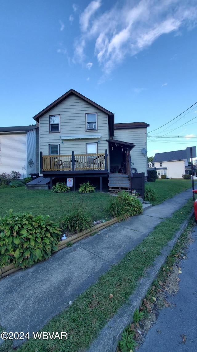 view of front facade with a wooden deck and a front yard