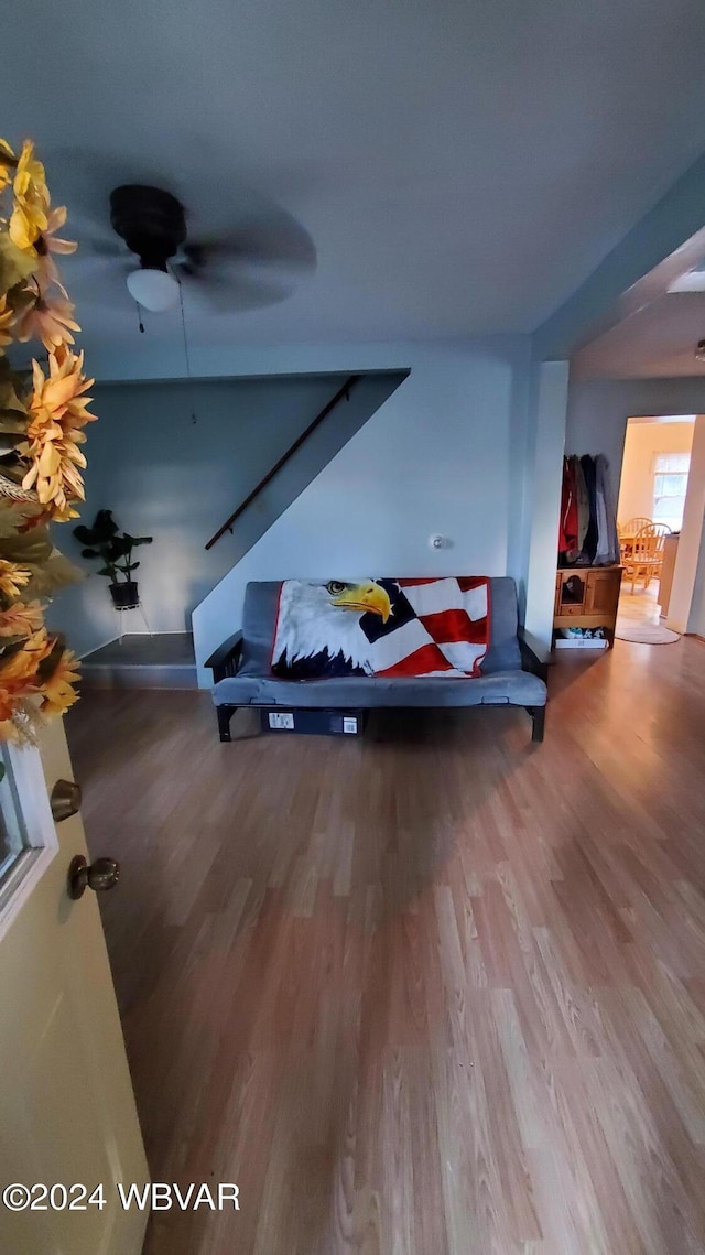 living room featuring hardwood / wood-style floors and ceiling fan