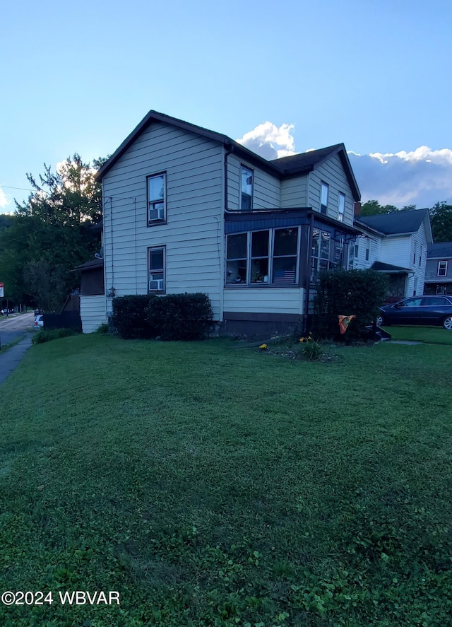 view of home's exterior with a sunroom and a yard