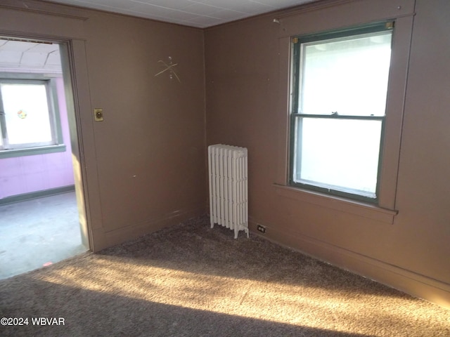 carpeted empty room with radiator