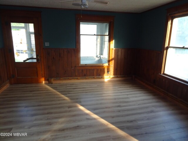 5047 Blockhouse Rd, Liberty, PA 16930 - spare room featuring a wainscoted wall, wood finished floors, wood walls, and a ceiling fan
