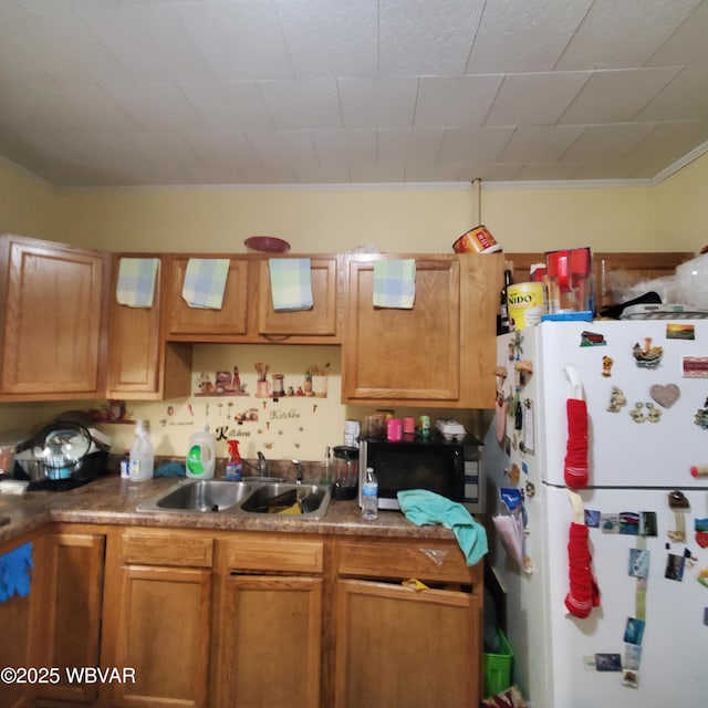 kitchen featuring white refrigerator and sink