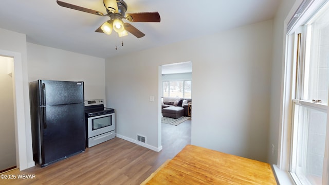 kitchen featuring ceiling fan, stainless steel electric stove, wood-type flooring, and black fridge