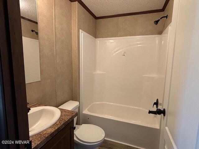 full bathroom featuring a textured ceiling, toilet, vanity, bathtub / shower combination, and ornamental molding