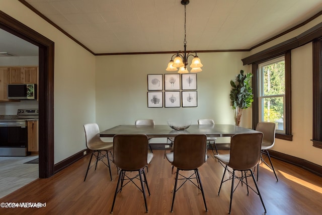 dining space with light wood-type flooring, crown molding, and a notable chandelier