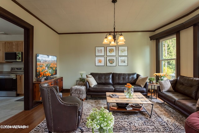 living room with light hardwood / wood-style floors, an inviting chandelier, and ornamental molding