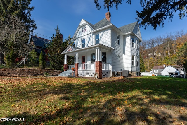 view of front of home with central AC unit, covered porch, and a front lawn