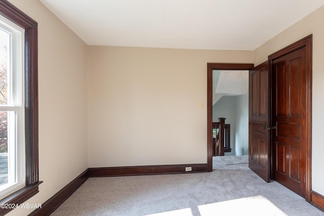 empty room with light colored carpet and a wealth of natural light