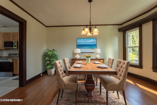 dining space featuring hardwood / wood-style flooring, an inviting chandelier, and crown molding