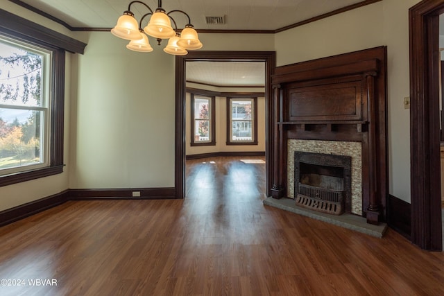 unfurnished living room featuring ornamental molding, dark wood-type flooring, and a notable chandelier