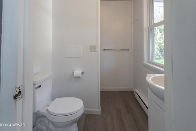 bathroom featuring wood-type flooring, vanity, a baseboard radiator, and toilet