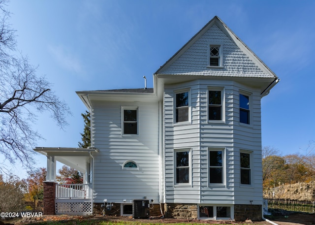 back of house featuring covered porch and central AC