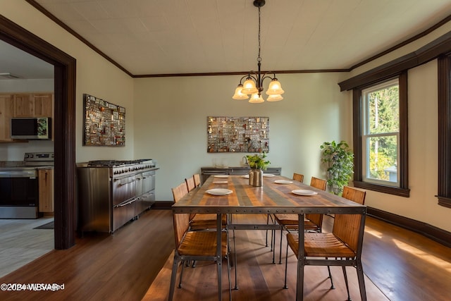 dining space with hardwood / wood-style flooring, an inviting chandelier, and crown molding